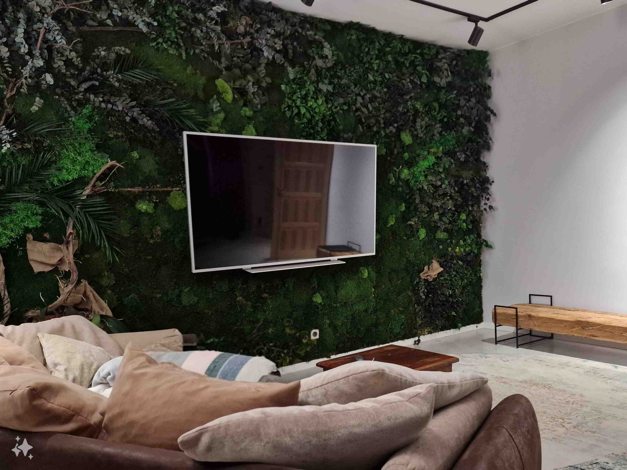 Cała ściana w salonie ozdobiona roślinnością stabilizowaną.